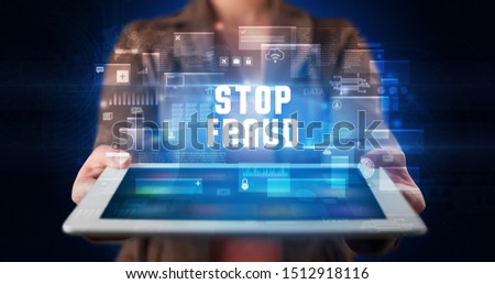 Young business person working on tablet and shows the digital sign: STOP FRAUD