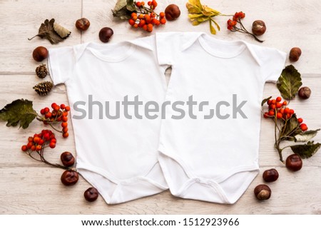 Mockup of two white baby bodysuit shirts in autumn style