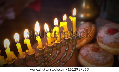 The Hanukkah menorah is a nine-branched candelabrum lit during the eight-day holiday of Hanukkah. Sufganiyah is a round deep-fried jelly doughnut eaten in Israel