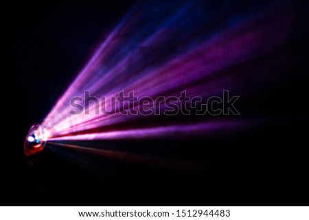 Purple color wide lens projector with light beam for movie video and cinema at night . abstract smoke texture spotlight screening for multimedia production on black background .