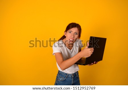 woman in t-shirt holds laptop electronic equipment