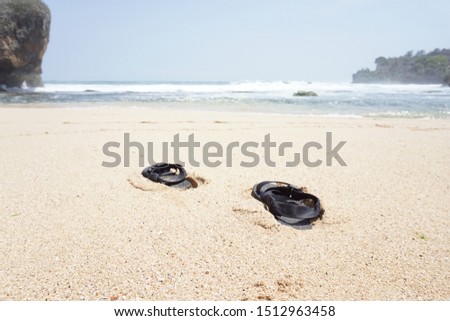 Mountain sandals on the beach against a backdrop of white sand and ocean waves.