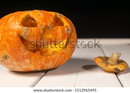 Halloween pumpkin on a wooden table on a background of white boards. Halloween background. Space for text.