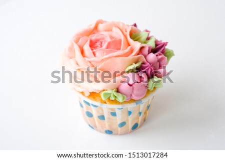 Cupcakes with colorful cream flowers on white background. Picture for a menu or a confectionery catalog.