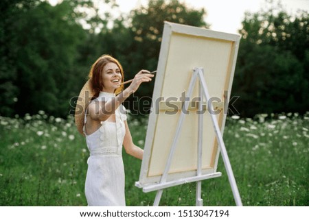 woman in a clearing draws a picture easel