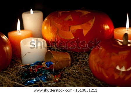 
Halloween pumpkin and candles on a table with a straw