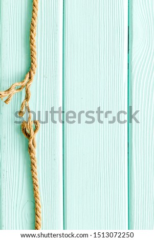 Tearing the rope under stress on mint green wooden background top view copyspace