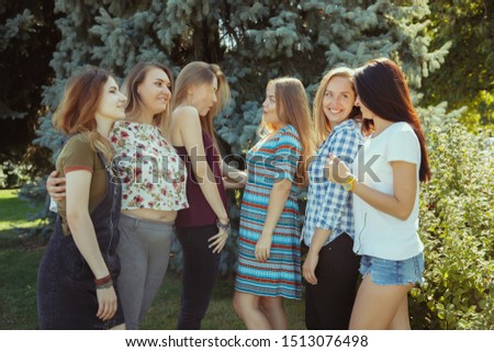 Different and happy in their bodies. Young women smiling, talking, walking and having fun together outdoors on sunny summer's day at park. Girl power, feminism, women's rights, friendship concept.