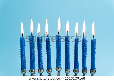 Menorah with lit candles in celebration of Chanukah. A symbolic candle lighting for the Jewish holiday of Hanukkah. The eighth and final night of Hanukkah.