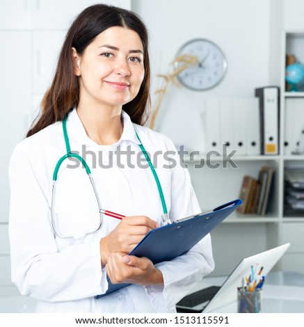 Woman is standing with documents in clinic