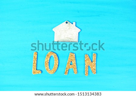Home and "LOAN" on the blue wood background. Concept Finance. Loan Concept