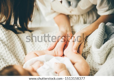 Baby feet in mother hands. Mom and her daughter. Happy family concept. Conceptual image of maternity.
