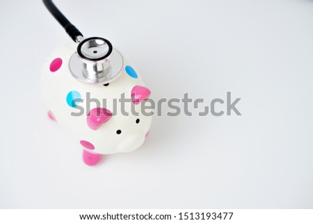Cute Colorful Piggy bank with stethoscope isolated on white. Financial Concept