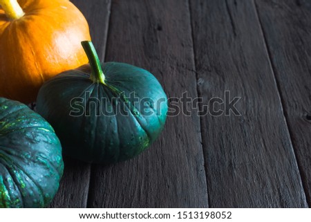 Orange pumpkin and green squash on a wooden table. Harvest season