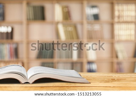 Open book on old wooden table.