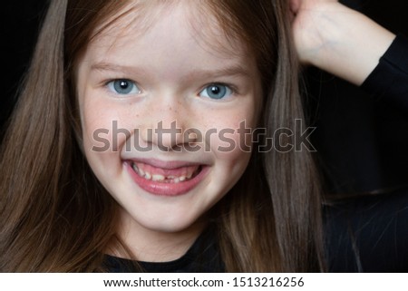 portrait of a little beautiful girl with long hair on a dark background