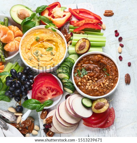 Healthy vegan snacks and dips. Flatlay of party food. Top view on gray background. Clean diet eating, veggie serving table