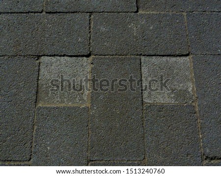 patio stone brick paving block background image. pattern and texture. landscaping materials concept. gray concrete bricks. interlocking pavers. sidewalk paving material. rough sandy texture.