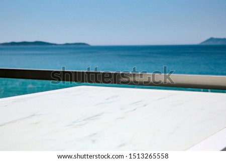 White wooden table and free space for your decoration. Sea landscape and blue sky. 