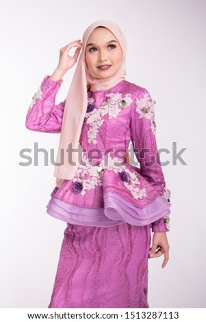 Beautiful female model wearing light purple peplum dress with hijab, a modern lifestyle outfit for wedding ceremony isolated over white background. Malay wedding dress concept.
