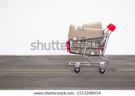 Shipping Box with shopping cart trolley on wood table