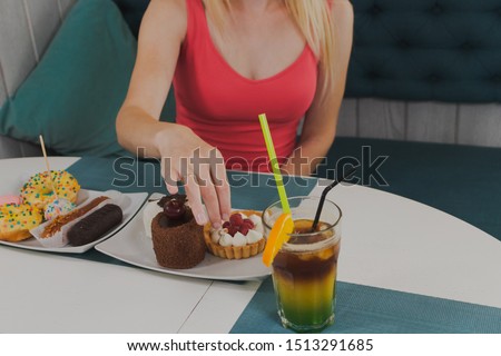 Girl in a cafe eats sweet and fresh desserts.