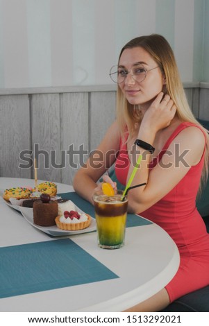 Girl sitting in a cafe with a plate of desserts.