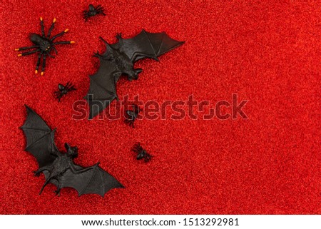 Top view of Halloween decoration with plastic black and golden bats over glitter background. Party, invitation, halloween decoration concept