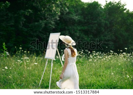 young woman in nature paints a picture