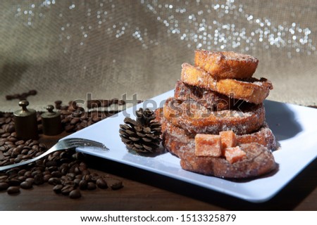 French toast, sliced sweet bread, unfocused foreground. Selective focus .Coffee beans. Rabanada brasileira .White dish, dark background .Christmas sky.Breakfast.View from above. rom above. Royalty-Free Stock Photo #1513325879