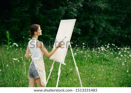 beautiful woman on nature in the forest draws a picture