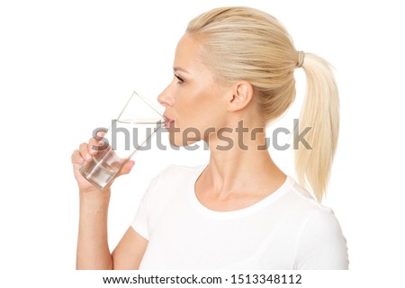 Profile picture of healthy and pretty woman drinking a glass of water. Model is isolated on white background.