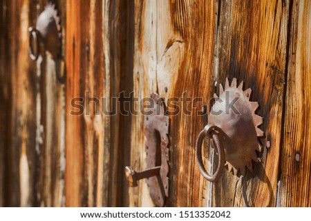 Two metal handles in the form of a ring on the old wooden door.