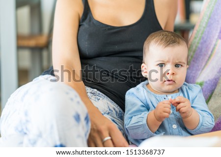 baby crying with discomfort and fever incubating the flu virus, looking at the camera