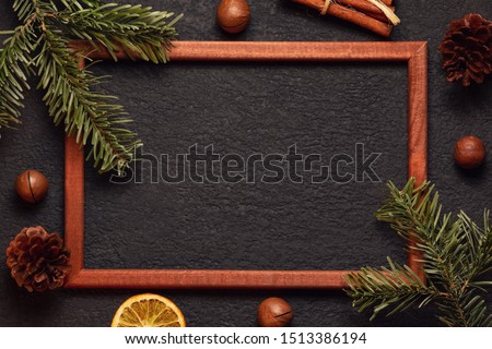 Christmas composition, blank for greeting card or other design - Christmas tree branches with wooden frame and decorations on a dark background, flat lay, top view, copy space, place for text