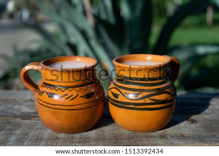 Traditional mexican fermented beverage called "Pulque" in clay cups with agave cactus Royalty-Free Stock Photo #1513392434