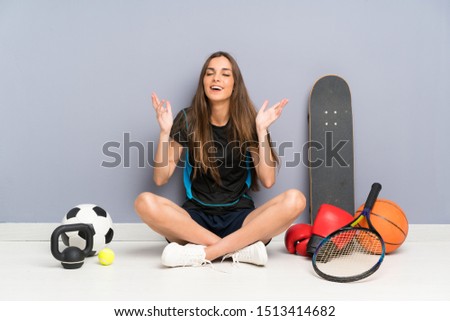 Young sport woman sitting on the floor laughing