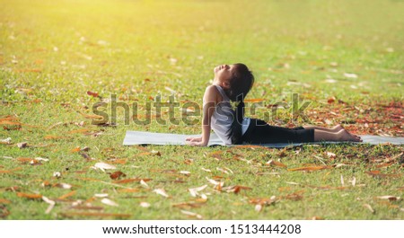 beautiful asia children girl flexible doing yoga at public park morning holiday. kid sport healthy concept