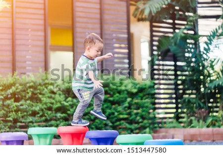 2.6 years old.Little toddler boy walking in colorful balance toy in playground at kindergarten school. Practice Gross Motor Skills concept. Royalty-Free Stock Photo #1513447580