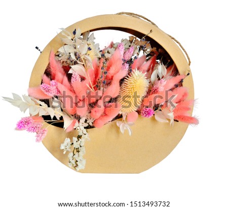 Delicate floristic composition in pastel white pink color from dried flowers in gift box, close up, isolated on white background. Bouquet from fluffy lagurus, limonium, statice, teasel. Floristry 