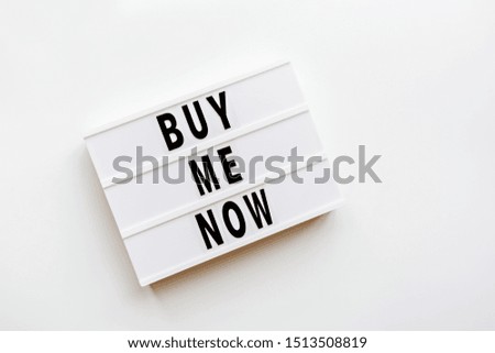 Creative promotion composition buy me now text on lightbox on white background. Flat lay, top view, overhead, mockup, copy space, template