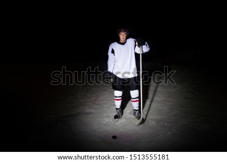 Hockey player. Portrait of a handsome ice-hockey player with hockey stick