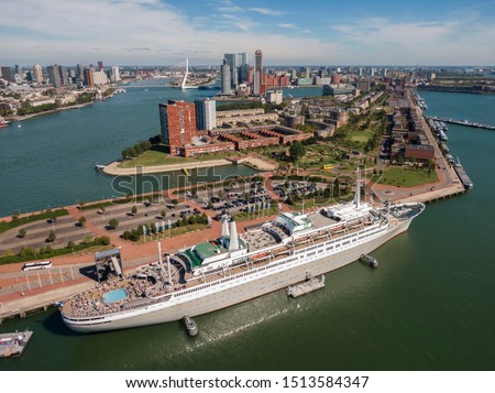 aerial of SS Rotterdam ship moared on Katendrecht land head with skyline of towers and Erasmus bridge in the background  Royalty-Free Stock Photo #1513584347