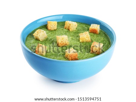 Bowl of green cream soup with pea, broccoli, spinach, kale and croutons isolated on white background. With clipping path.
