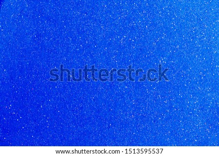 Abstract detail background of a vivid bright blue glitter shining and sparkling. Full frame sky cyan noise color backdrop element.