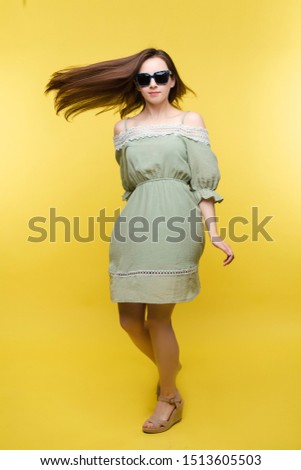 Girl in dress and sunglasses in motion.