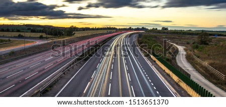 Colourful sunset at M1 motorway near Flitwick junction with blurry cars in United Kingdom