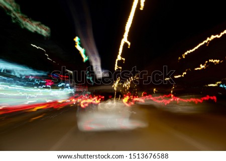 Long exposure.Colorful bokeh with street lights at night,motion with traffic lighting scene in the city on car windshield view,blur background.Speed fast with driving car. Abstract Background.