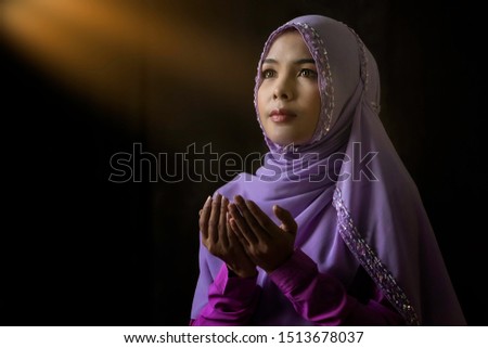 Close up. Muslim women wearing purple shirts Doing prayer According to the principles of Islam.
