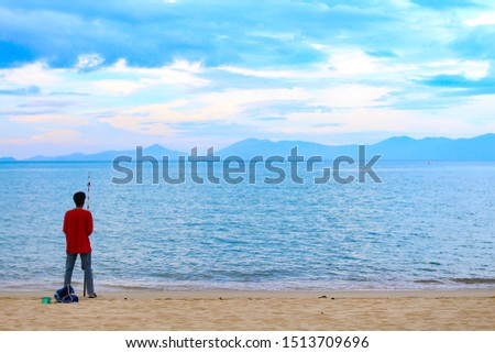 Picture of a man fishing on the beach.